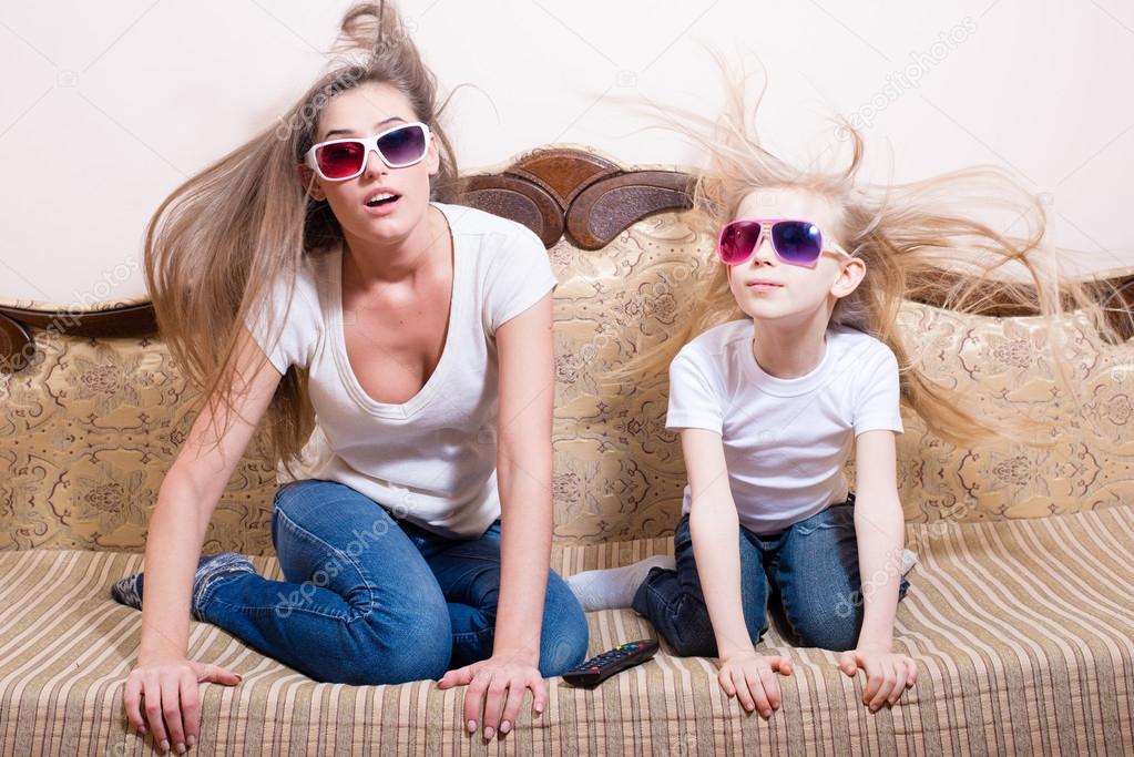 Woman with little girl watching 3D movie in 3D glasse