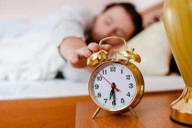 Man pulling his hand  to the alarm clock clipart