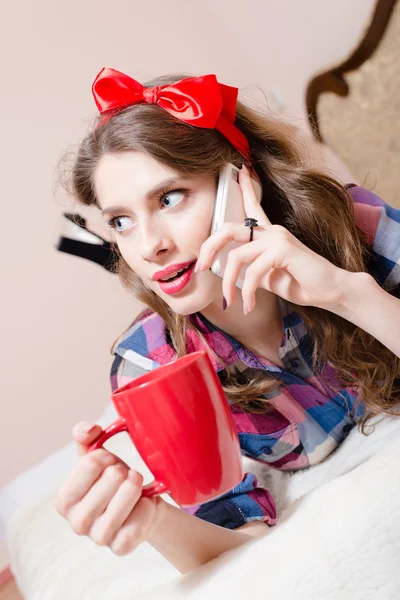 Femme avec téléphone portable et tasse rouge — Photo