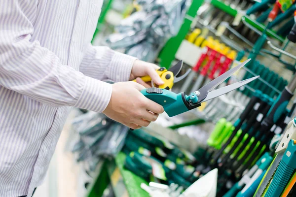 Att välja och köpa sax för beskärning trimning träd buskar gräs i trädgårdsredskap institutionen på diy shopping store bakgrund — Stockfoto