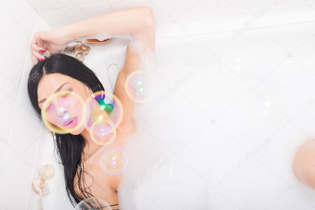 Woman  blowing bubbles  in the bath