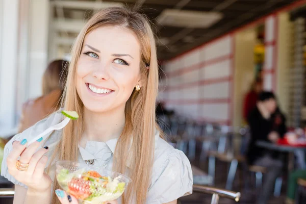 Mujer sentada en la cafetería sosteniendo una deliciosa ensalada —  Fotos de Stock
