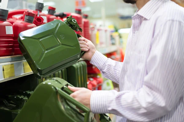 Hombre sosteniendo dos latas verdes de tamaño en un supermercado —  Fotos de Stock