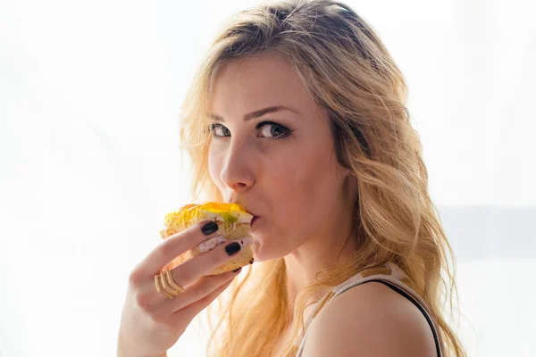 Imagem de degustação delicioso bolo bela jovem mulher loira sexy feliz sorrindo e olhando para câmera close-up retrato — Fotografia de Stock