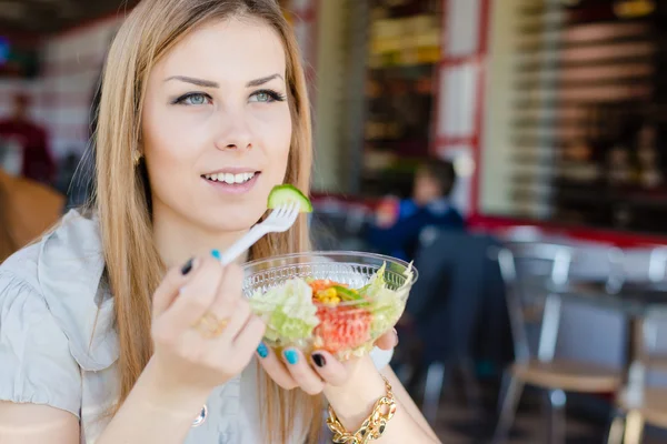Zbliżenie portret pięknej młodej kobiety blond, zielone oczy dziewczyny jedzenie sałatka w restauracji zabawy relaksujące, patrząc w okno obrazu lub obraz — Zdjęcie stockowe