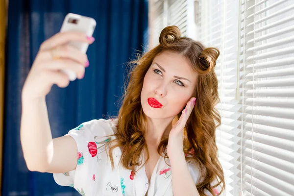 Beautiful young pinup woman taking selfie photo with smart phone — Stock Photo, Image