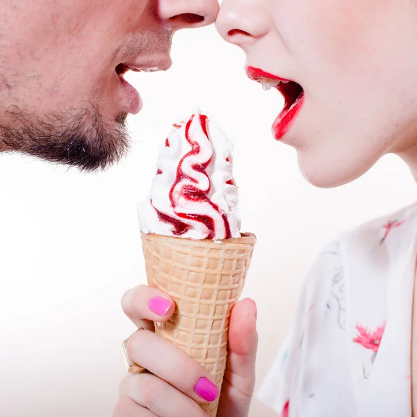 Happy couple eating one icecream cone face closeup isolated on white background — Stock Photo, Image