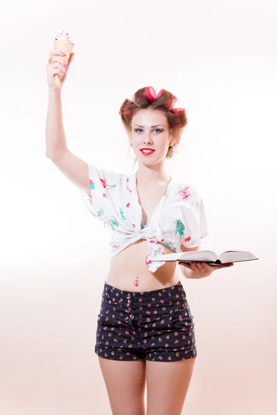 Mooie jonge pinup vrouw met icecream en boek die zich voordeed als standbeeld van vrijheid op zoek in de camera geïsoleerd op witte achtergrond — Stockfoto