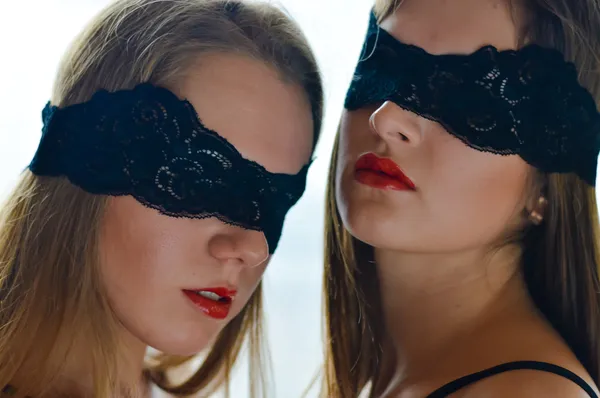 2 geblinddoekt mooie sexy jonge vrouwen sensuele vriendinnen permanent samen ogen blind gevouwen in kant en camera kijken op witte achtergrond close-up portret beeld — Stockfoto