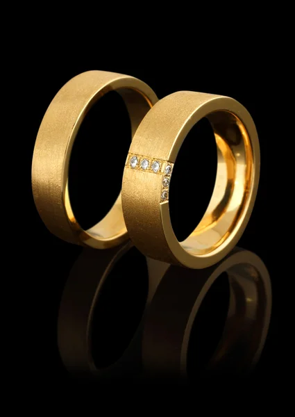 Anelli nuziali in oro con diamanti isolati su nero — Foto Stock