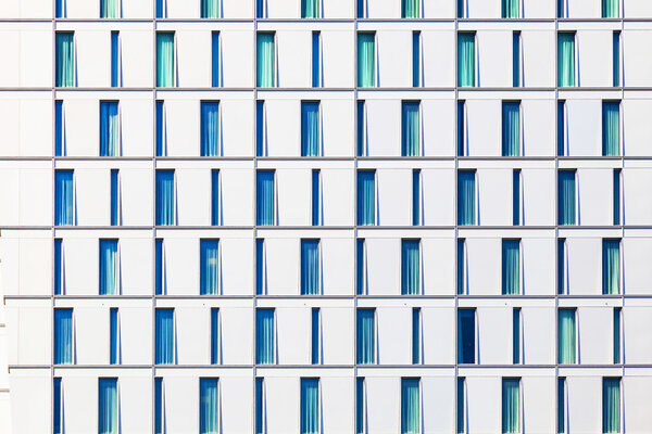 Facade of skyscraper with windows structured in rows with different forms