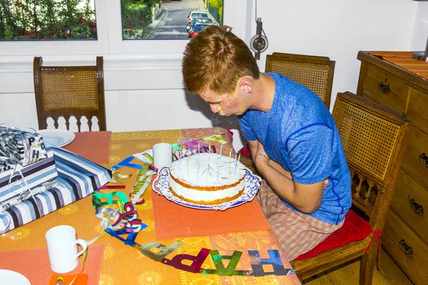Ragazzo soffiando le sue candele di compleanno alla torta — Foto Stock