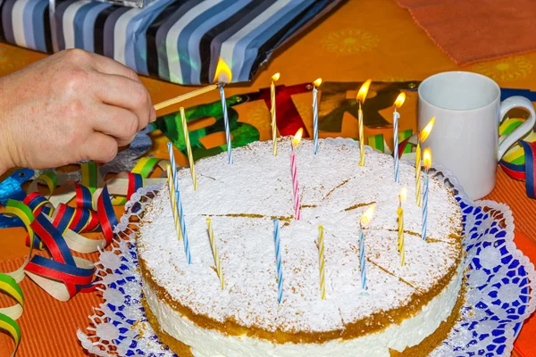 Acender as velas de aniversário no bolo — Fotografia de Stock