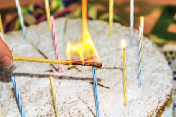Enciende las velas de cumpleaños en el pastel — Foto de Stock