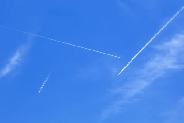 Diepblauwe hemel met vele contrails — Stockfoto