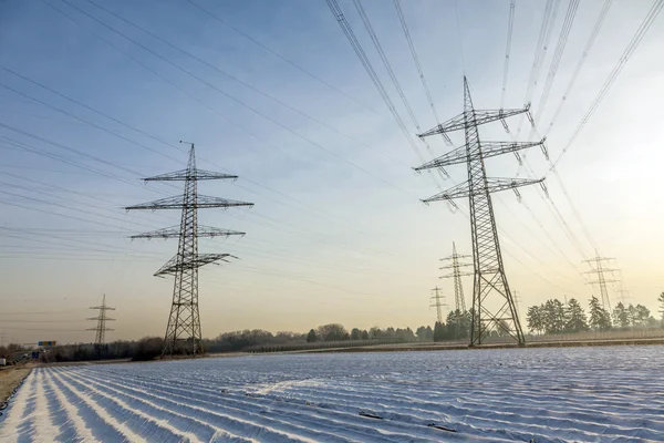 箔のフィールドと農村景観における電気タワー — ストック写真