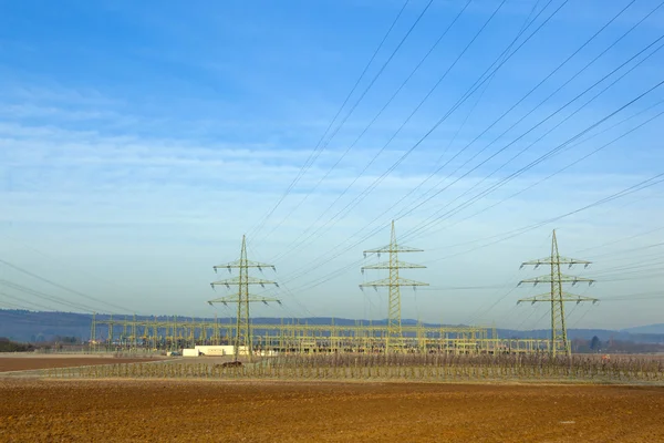 Wieża elektryczna w krajobrazie wiejskim z belą słomy — Zdjęcie stockowe