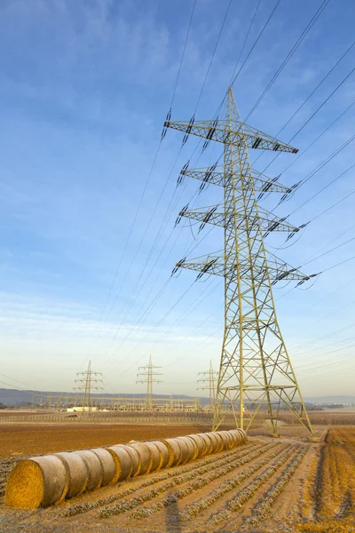 Электрическая башня в сельской местности с тюком соломы — стоковое фото