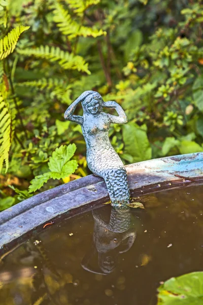 Pequeña murmaid sentado en el borde de un lavabo de metal y mirando — Foto de Stock