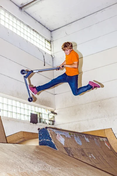 Junge hat Spaß beim Rollerfahren in der Skaterhalle — Stockfoto