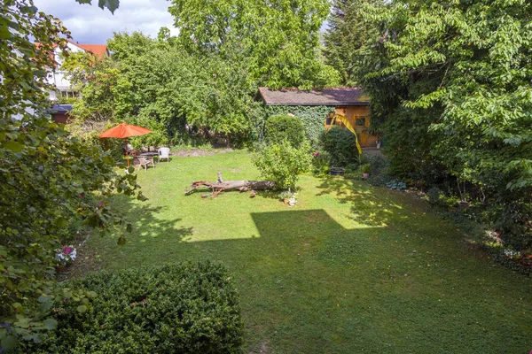 Jardim com cabana e guarda-chuva ao sol da tarde — Fotografia de Stock