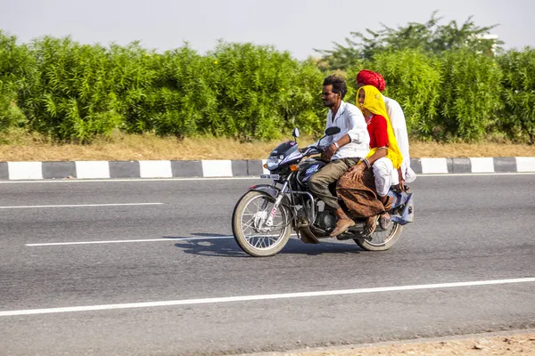 Madre, padre e hijo pequeño montando en scooter a través del ajetreado hola —  Fotos de Stock