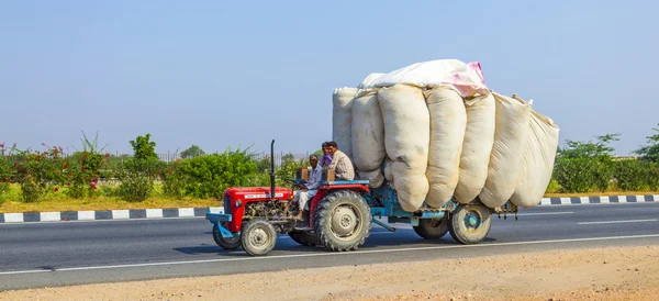 Transporte de palha com trator na estrada de campo — Fotografia de Stock