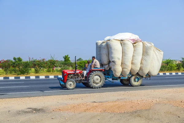 Transporte de palha com trator na estrada de campo — Fotografia de Stock