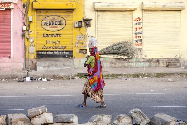 Женщина четвертого класса в ярко окрашенной одежде чистит улицу — стоковое фото