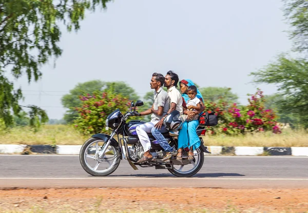 Мама, папа и маленький ребенок едут на скутере через занят привет — стоковое фото