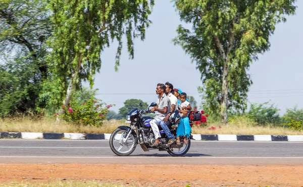Mor, far og småbarn rir på scooter gjennom travel hei. – stockfoto