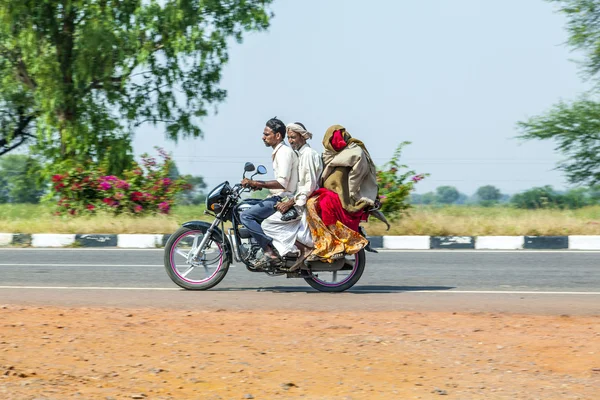 Mother, father and small child riding on scooter through busy hi — Stock Photo, Image