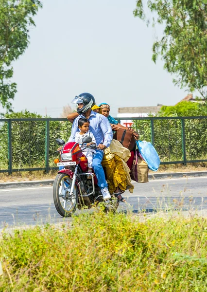 Mother, father and small child riding on scooter through busy hi — Stock Photo, Image