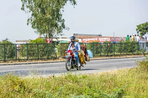 Mother, father and small child riding on scooter through busy hi — Stock Photo, Image