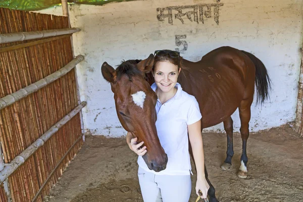 Donna con il suo cavallo che abbraccia nella stalla — Foto Stock