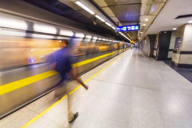 Metro trenini hizalayan yolcular
