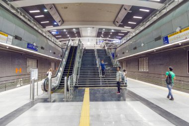 Metro trenini hizalayan yolcular