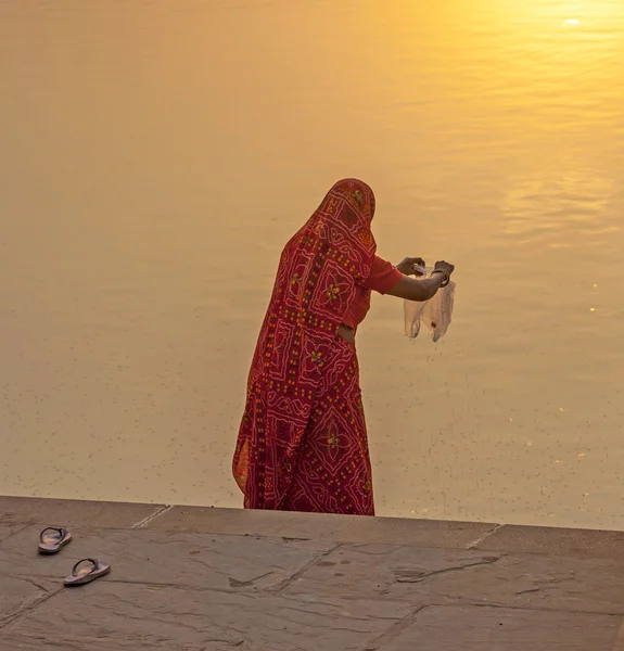 Mujer alimenta a los peces en el lago sagrado en Pushkar — Foto de Stock