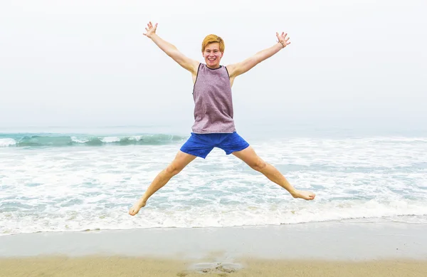 Cute young teenage boy has fun at the beach — Stock Photo, Image