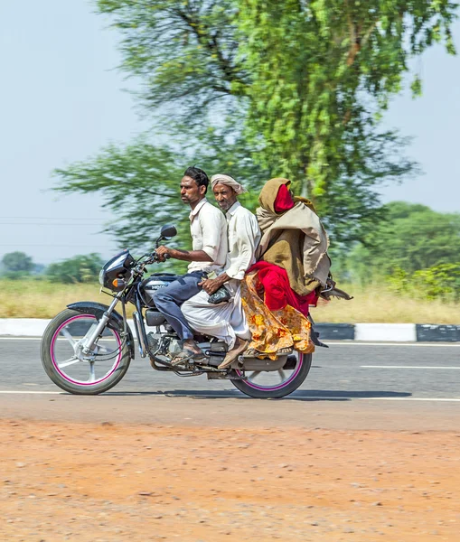 Madre, padre e hijo pequeño montando en scooter a través del ajetreado hola — Foto de Stock