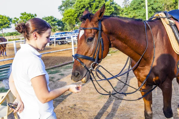 Femme cavalière étreignant avec son cheval — Photo