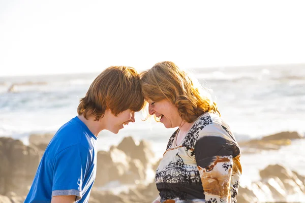 Mãe e filho desfrutar do sol da tarde na praia — Fotografia de Stock