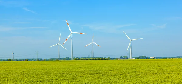 Windenergieanlagen stehen im Frühjahr auf dem Feld — Stockfoto