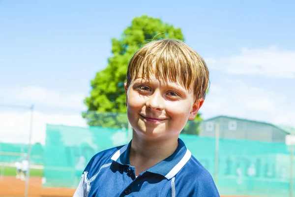 Dziecko wygląda szczęśliwy i zadowolony po meczu tenisa — Zdjęcie stockowe