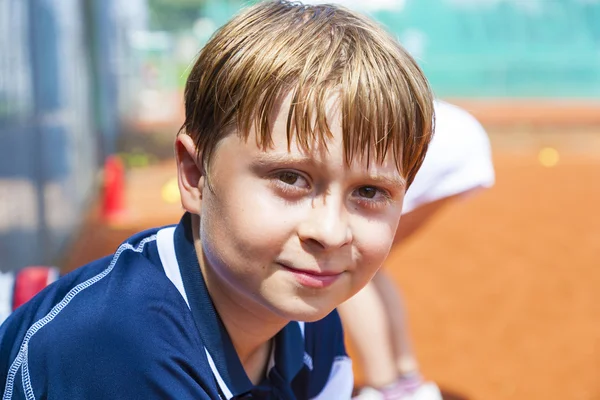 Niño se ve feliz y satisfecho después del partido de tenis —  Fotos de Stock