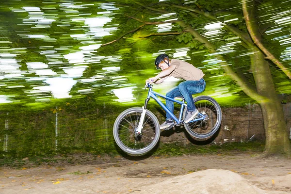 Kind hat Spaß dabei, mit dem Fahrrad über eine Rampe zu springen — Stockfoto