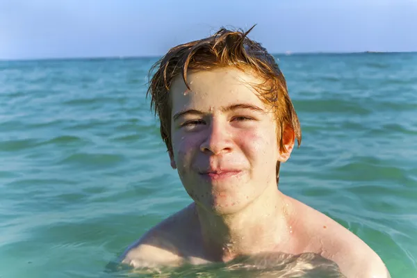 Jongen met rood haar is genieten van het duidelijk warm water op de beauti — Stockfoto