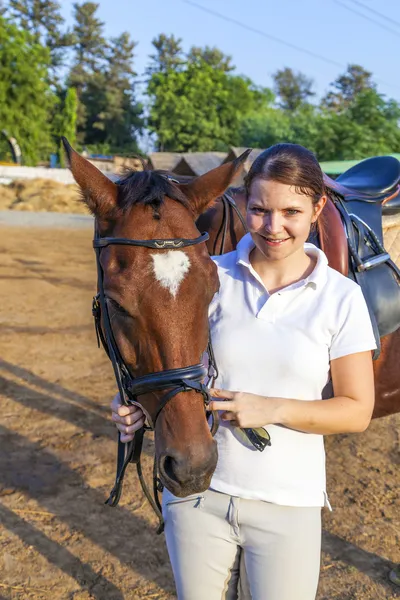 Mulher cavaleiro abraçando com seu cavalo — Fotografia de Stock