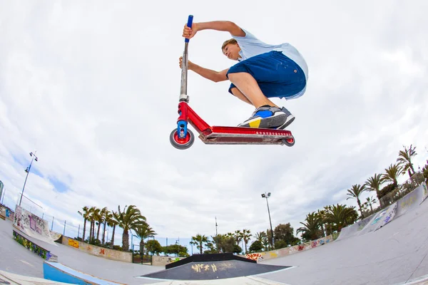 Menino monta sua scooter no parque de skate — Fotografia de Stock