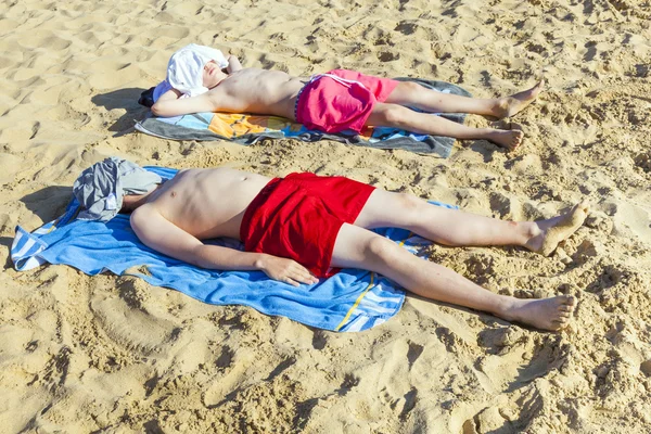 Irmãos relaxam e dormem na praia — Fotografia de Stock